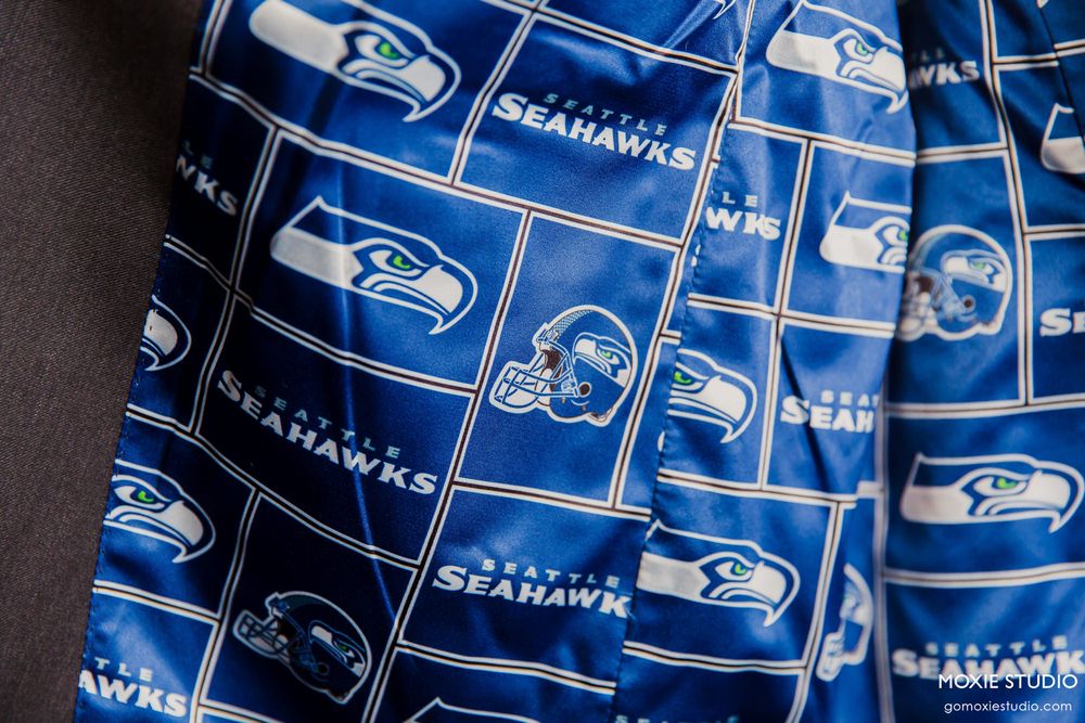 Repeating pattern of Seattle Seahawks NFL team logos and text in blue and white color scheme.