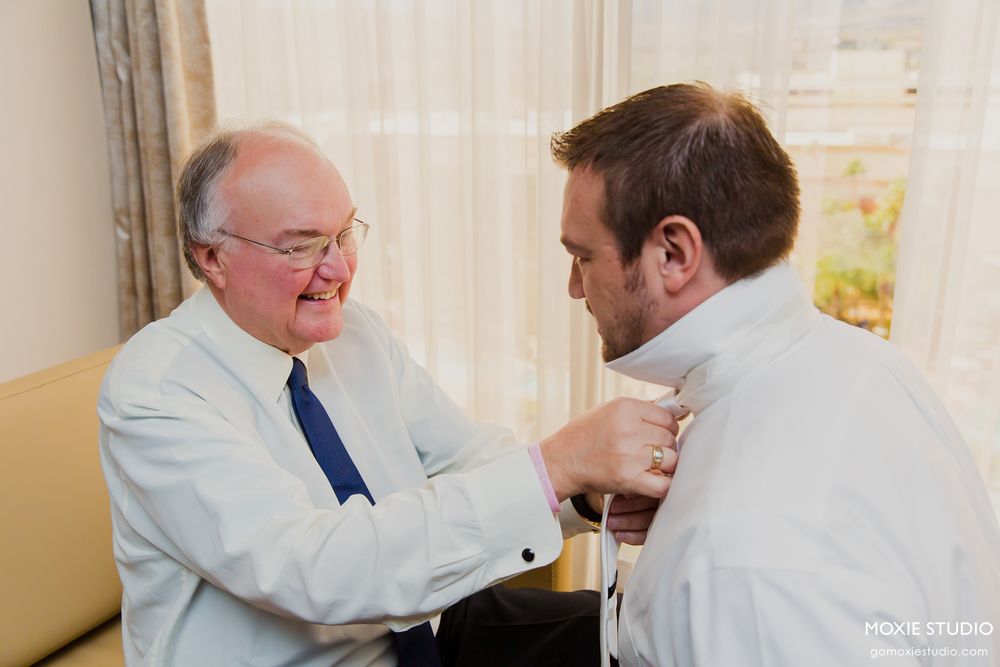 Two people in formal attire adjusting clothing and preparing for a special event.