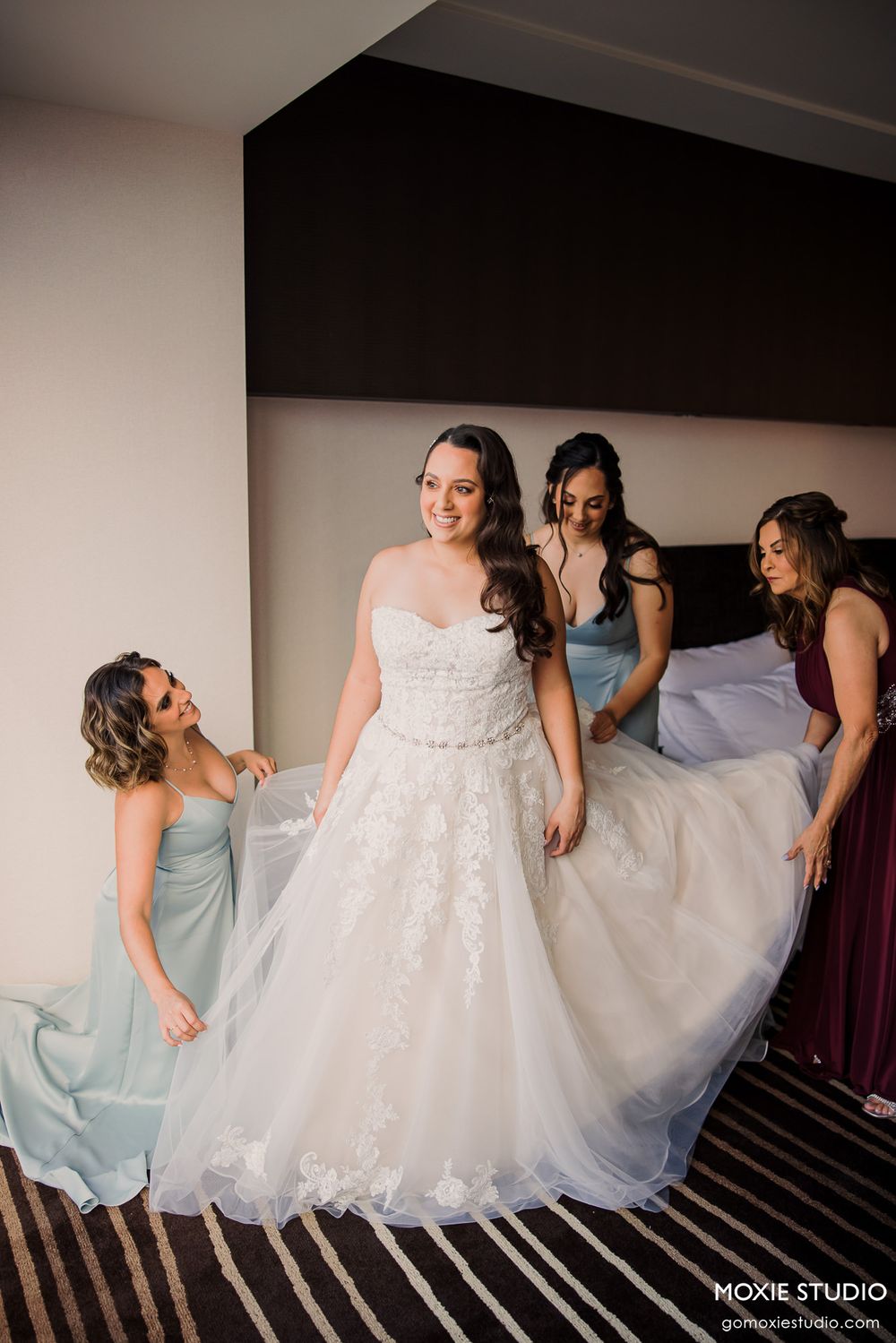 Bridesmaids in light blue dresses help adjust the bride's flowing white ballgown wedding dress in a sequence of photos.