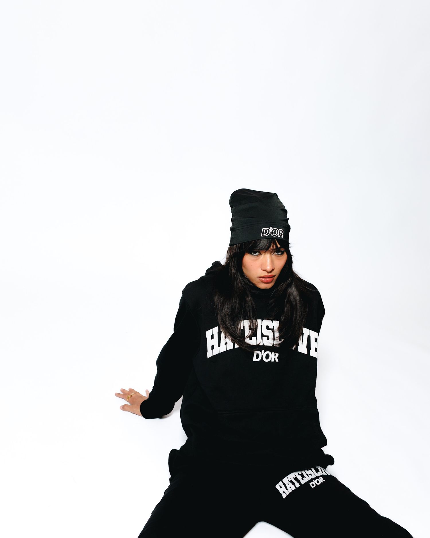 Person in black hoodie and beanie strikes dynamic poses against white background in three-panel sequence.