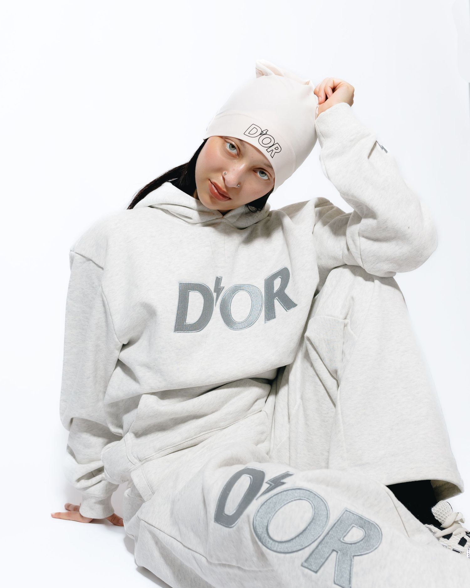 Model wearing a white oversized hoodie with 'DOR' text design shown from multiple angles in a fashion photo collage.
