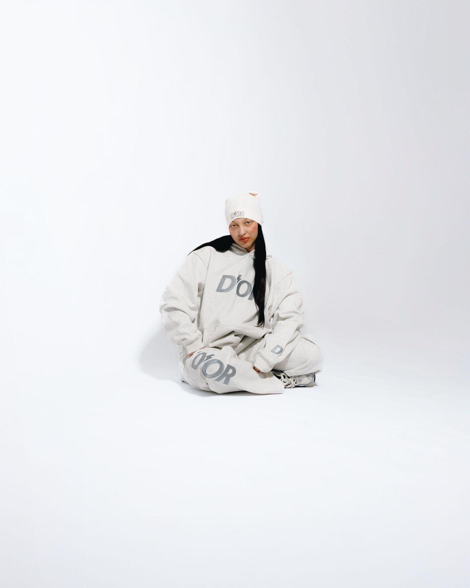 A figure in a white hoodie and sweatpants strikes three dynamic poses against a light gray studio background.