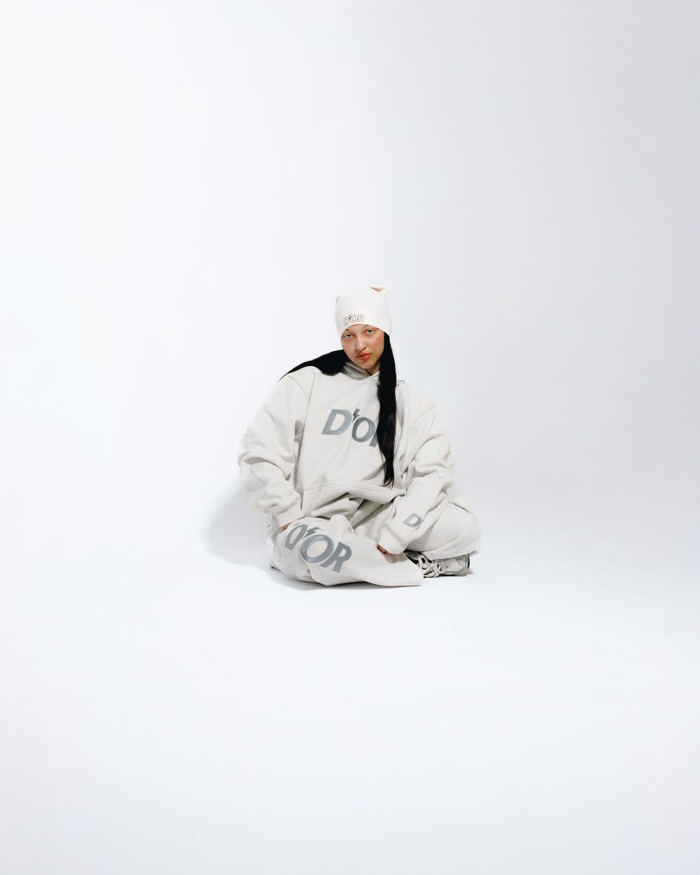 A figure in a white hoodie and sweatpants strikes three dynamic poses against a light gray studio background.