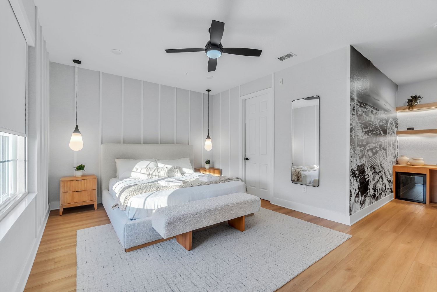 Modern white bedroom interior with wood flooring, pendant lights, and vertical shiplap wall paneling. real estate media in central florida,