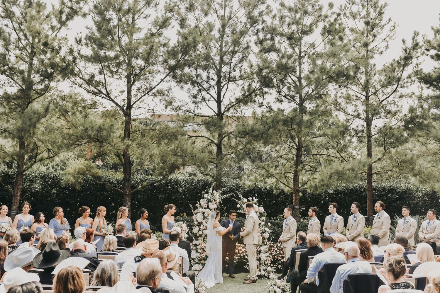 Bride and groom exchanging rings during timeless outdoor wedding ceremony
