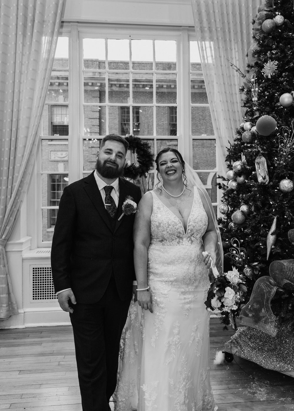 candid photo of Bride and Groom smiling inside East ballroom at the Yorktowne Hotel in York PA before their elegant winter wedding ceremony.