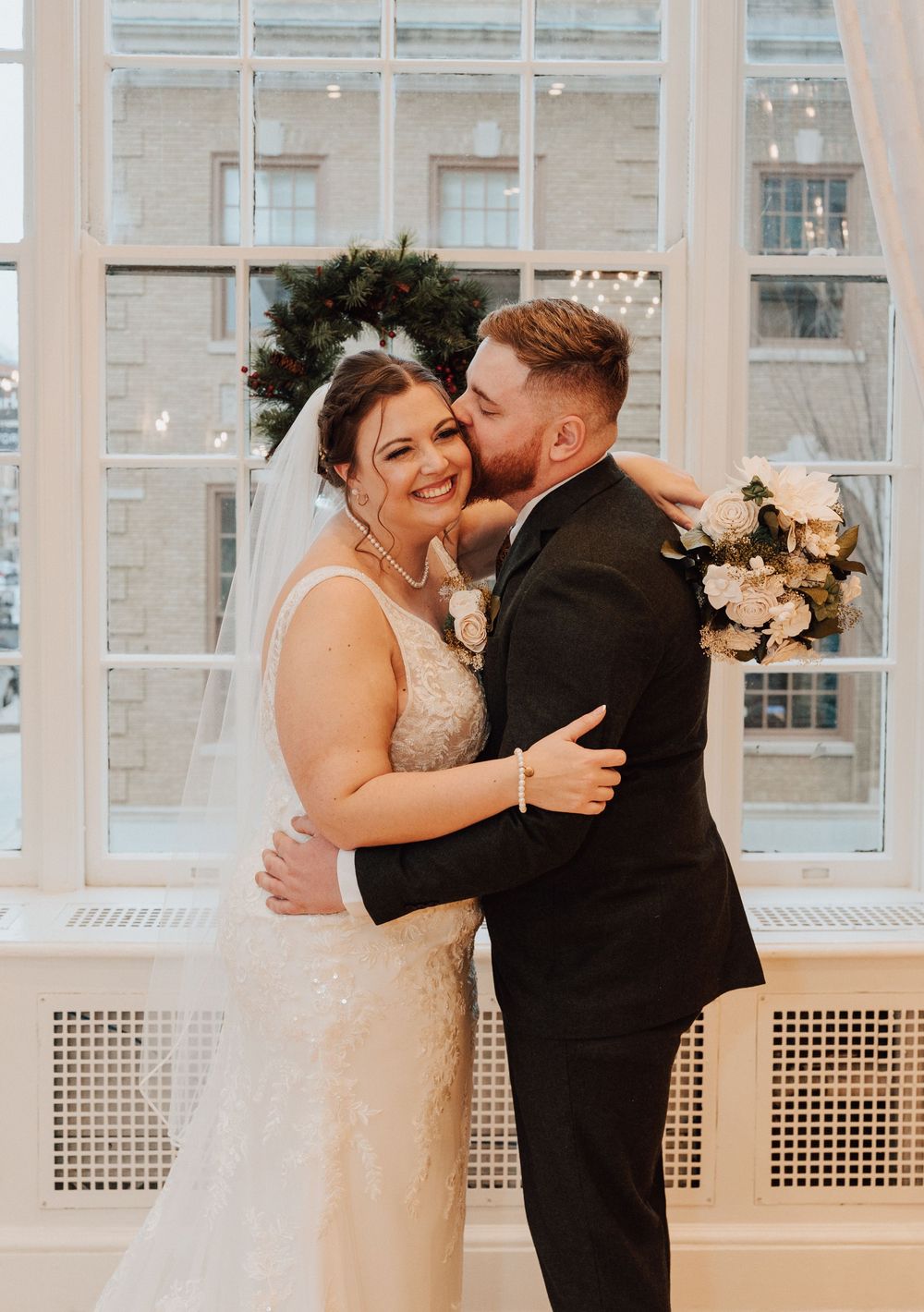 candid photo of Bride and Groom smiling inside East ballroom at the Yorktowne Hotel in York PA before their elegant winter wedding ceremony.