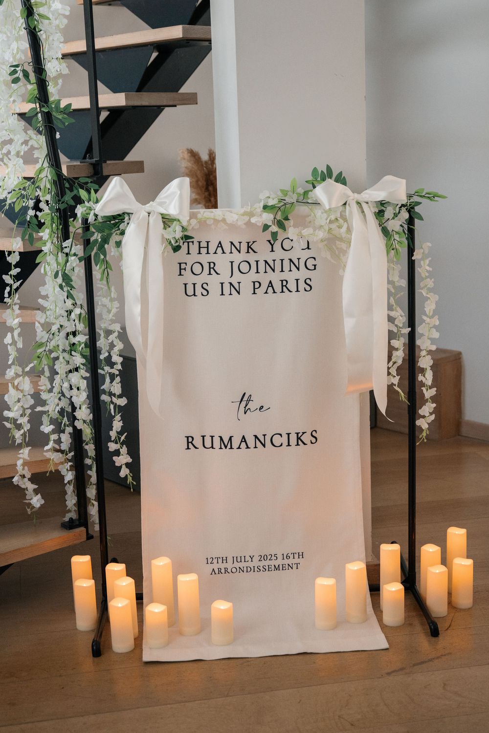 Wedding welcome sign with candles and floral decor reading Thank You For Joining Us in Paris.