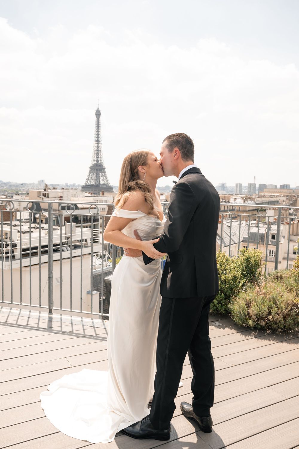 Romantic rooftop moment in Paris with Eiffel Tower visible in background.
