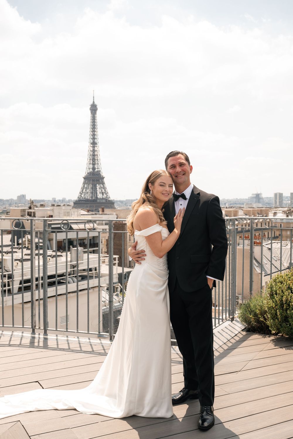 A romantic rooftop wedding photoshoot in Paris with the iconic Eiffel Tower visible in the background.