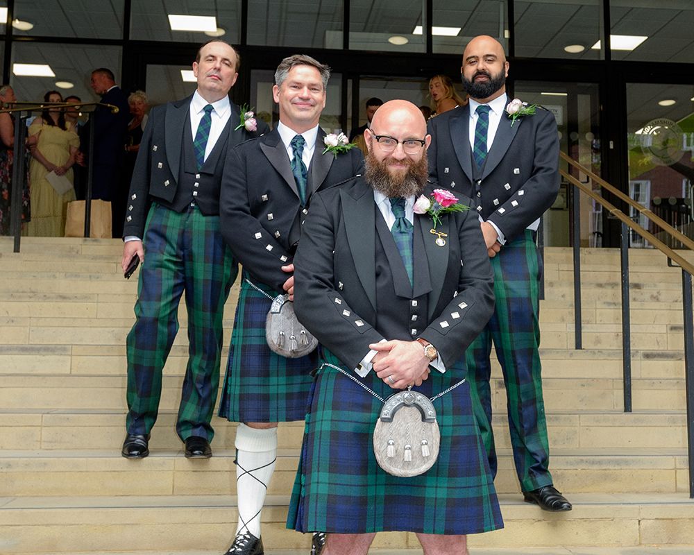 A group of men in kilts standing on steps, captured during a wedding in High Wycombe by Abigail's Studio.