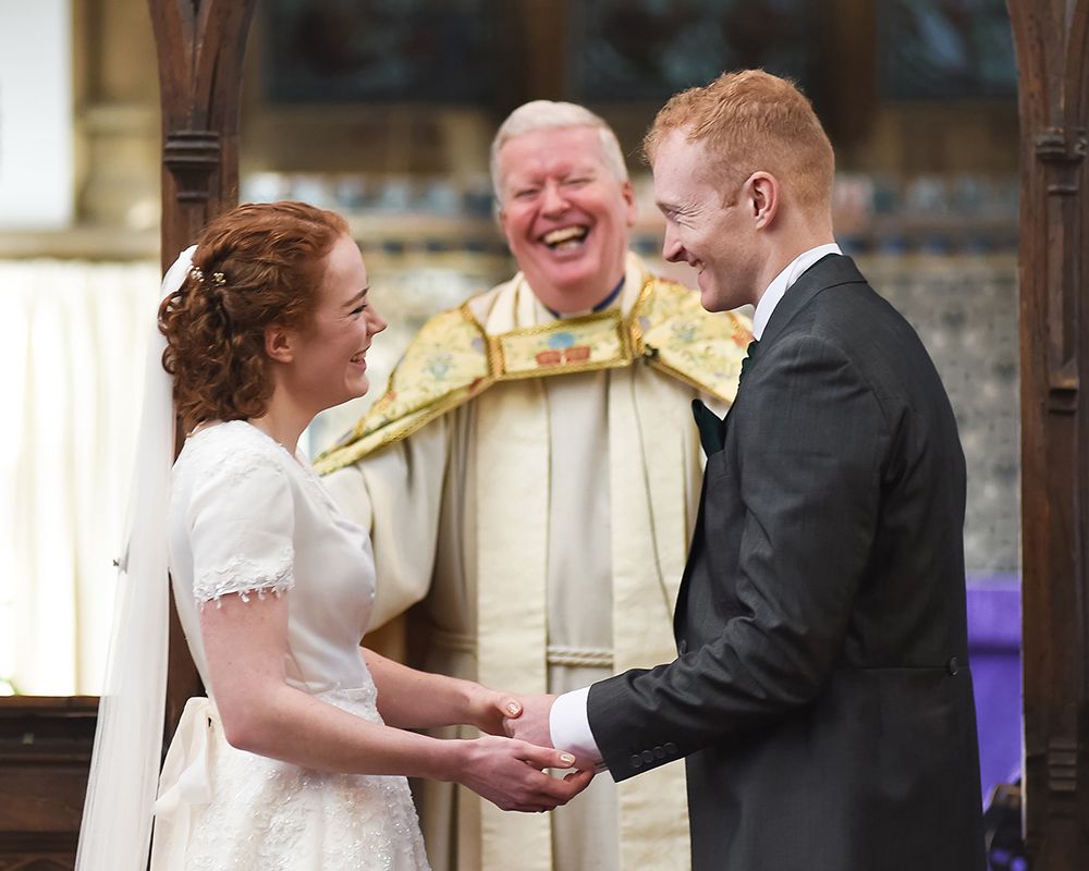 A bride and groom share a joyful smile during their wedding ceremony in High Wycombe, captured by Abigail's Studio.