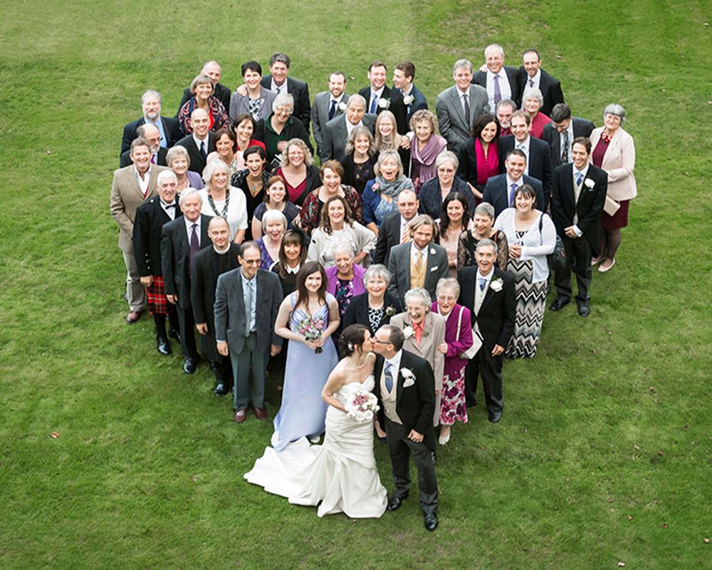 A large group of people celebrating a wedding in a field, captured by Abigail's Studio in High Wycombe.