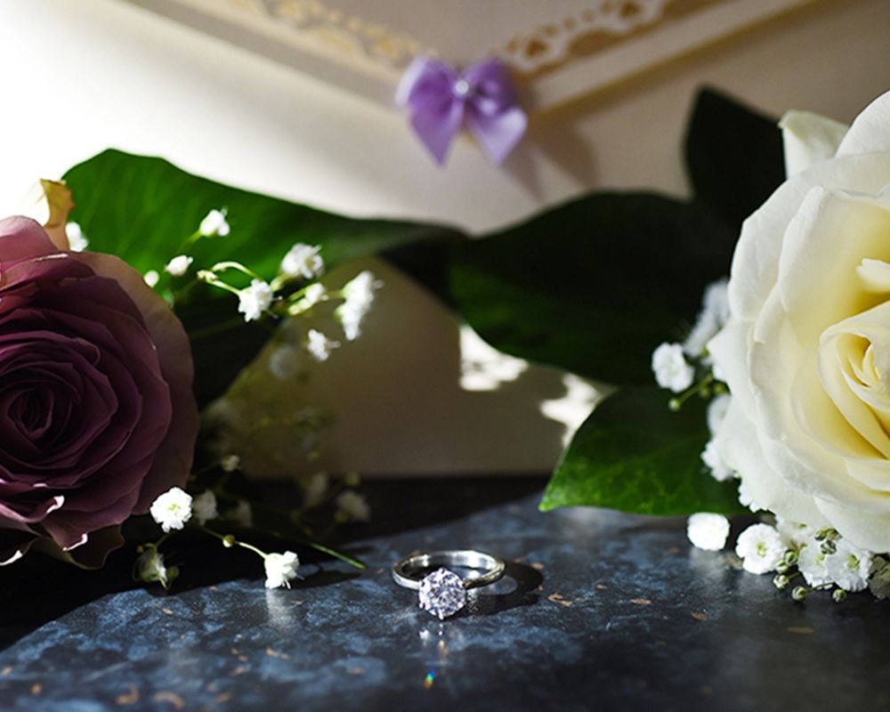 A wedding ring resting on a bouquet of flowers, captured in a romantic setting by Abigail's Studio in High Wycombe.