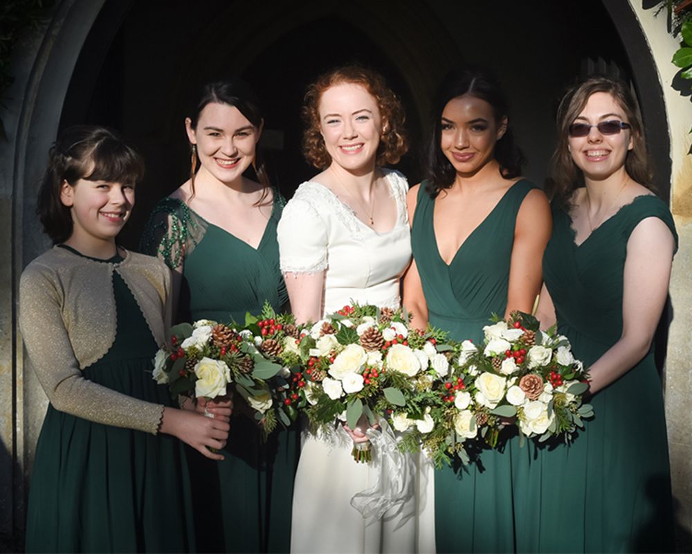Bridesmaids in elegant green dresses pose together for a wedding photo in High Wycombe, captured by Abigail's Studio.