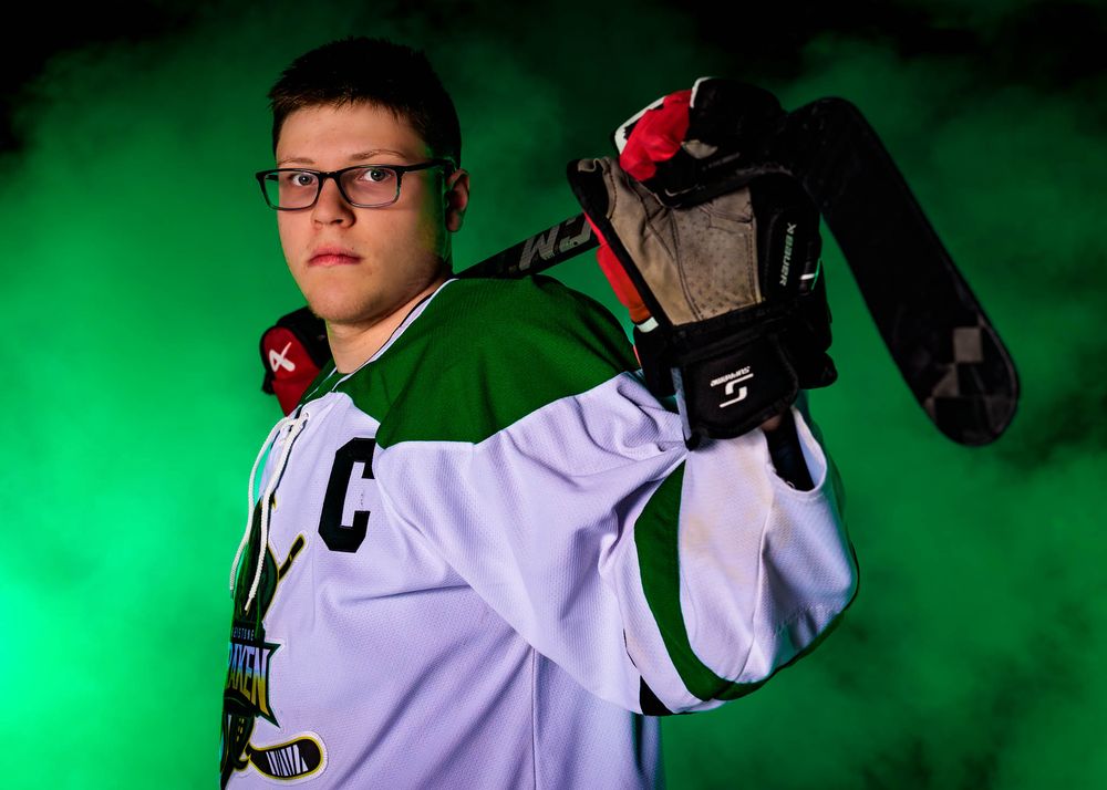 Close-up portrait of a Keystone Kraken hockey player in helmet and uniform, set against a green foggy background.