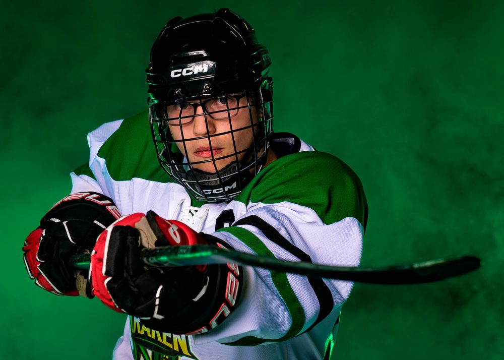 Close-up portrait of a Keystone Kraken hockey player in helmet and uniform, set against a green foggy background.