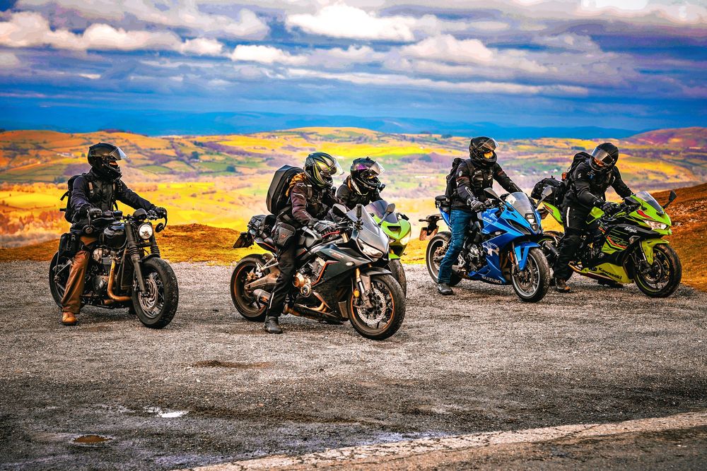 Row of custom motorcycles parked at sunset against dramatic orange and blue sky.