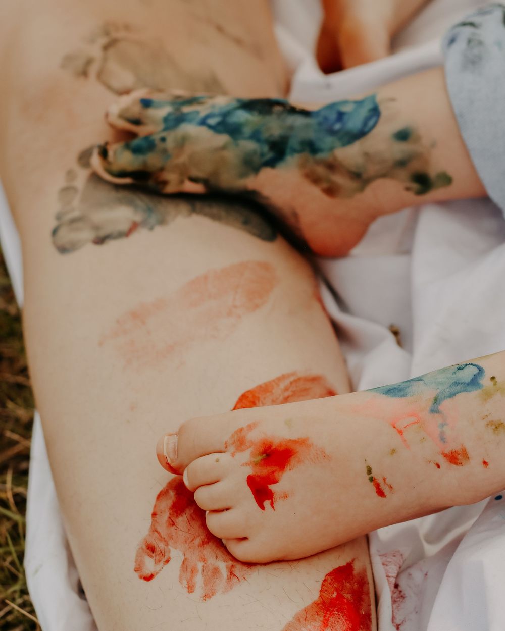 Close-up of hands creating colorful finger paint art in Williston, North Dakota.