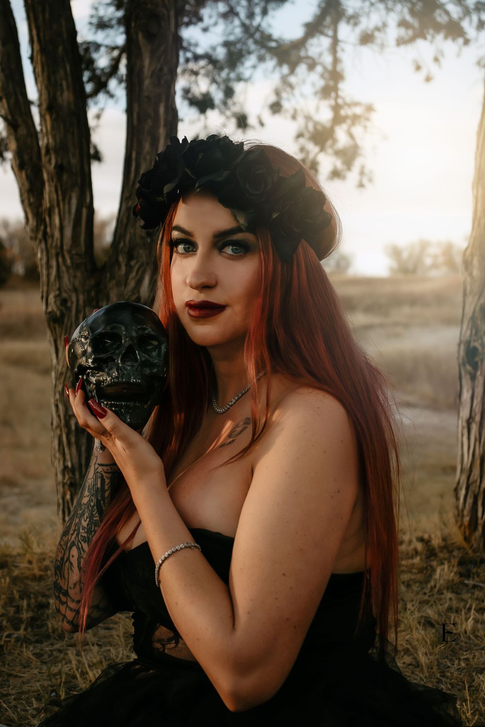 Artistic outdoor photo series of a photographer with long dark hair and red lipstick holding a vintage camera at sunset in Williston, ND.