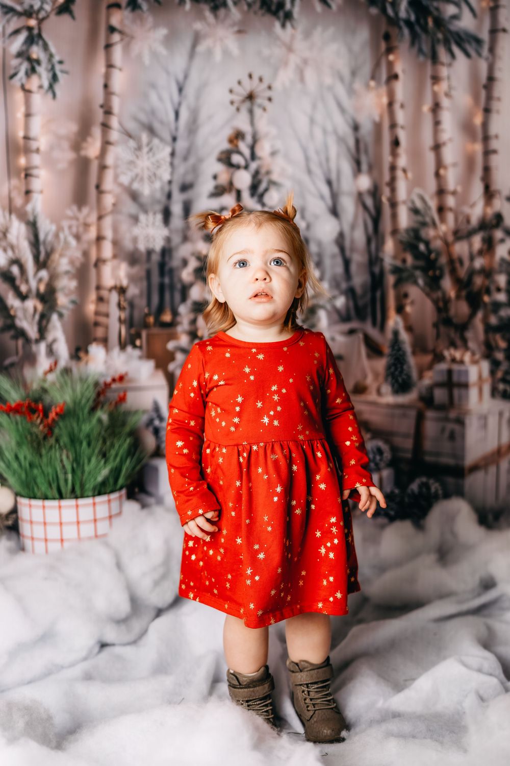 Festive winter scene with red dress and decorative snow-covered birch trees in Williston, North Dakota.