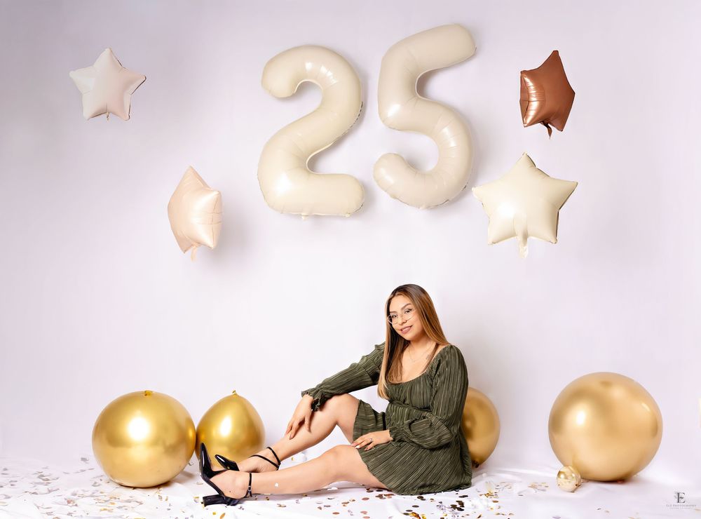 Birthday celebration setup with gold balloons and stars against white backdrop in Williston, North Dakota.