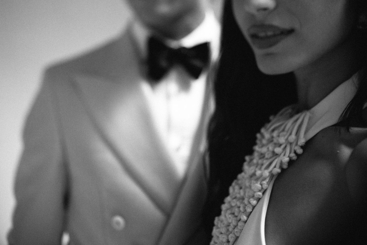 Romantic black and white portrait of a couple with one wearing a classic bow tie.
