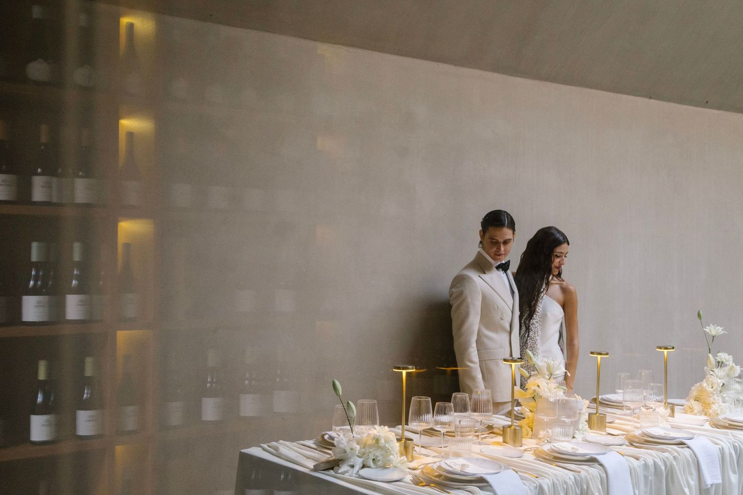 Modern dining setup in a minimalist room with white table settings and ambient lighting.