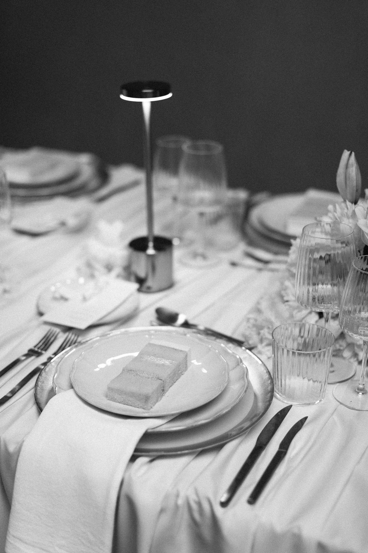 Elegant table setting with white plates, crystal glasses and formal cutlery arrangement.