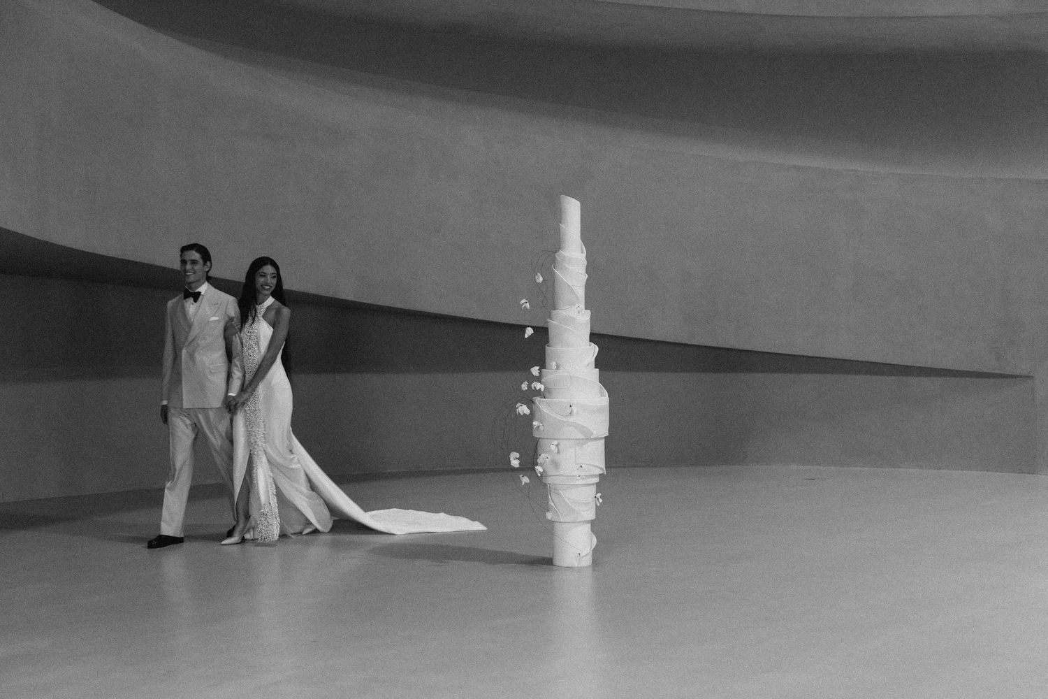 Minimalist wide-angle wedding photo showing figures and decor in dramatic silhouette.