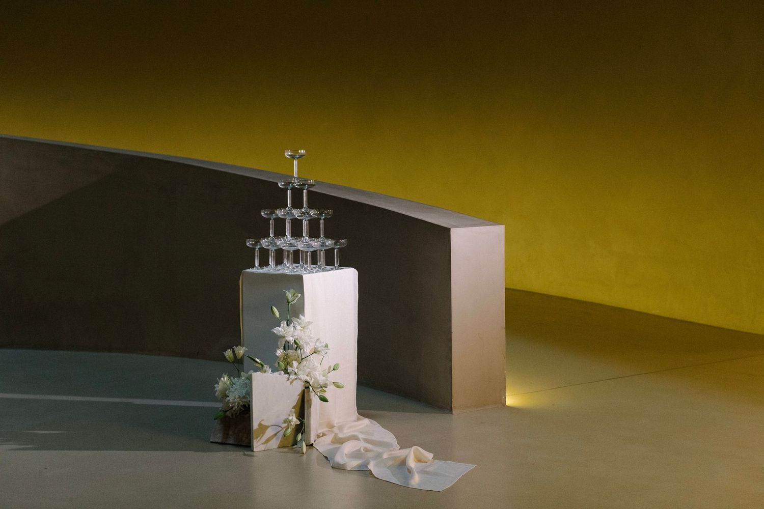 Wedding cake display with dramatic lighting against a dark background.