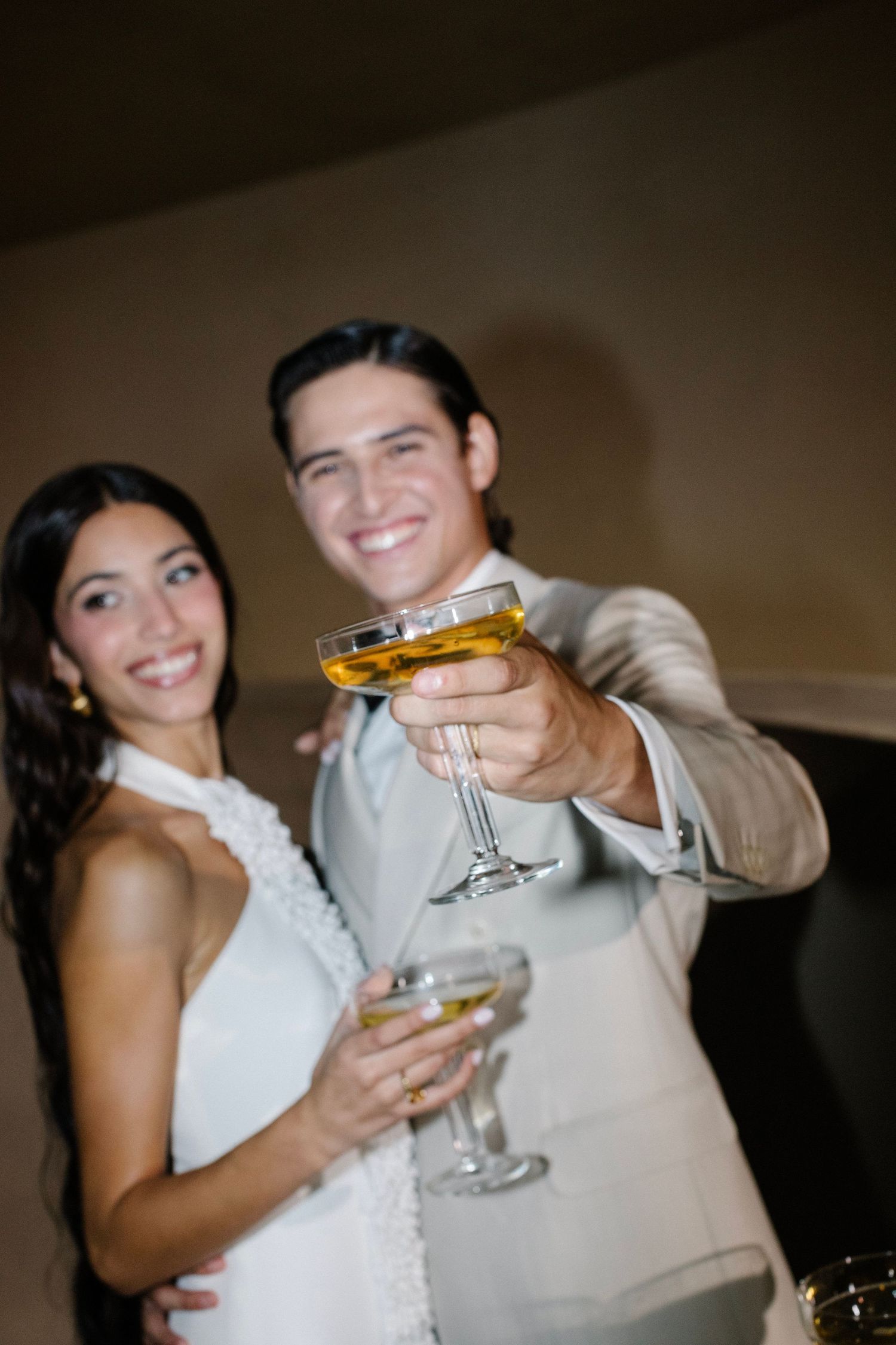 Wedding couple toasting with champagne glasses at their reception celebration.
