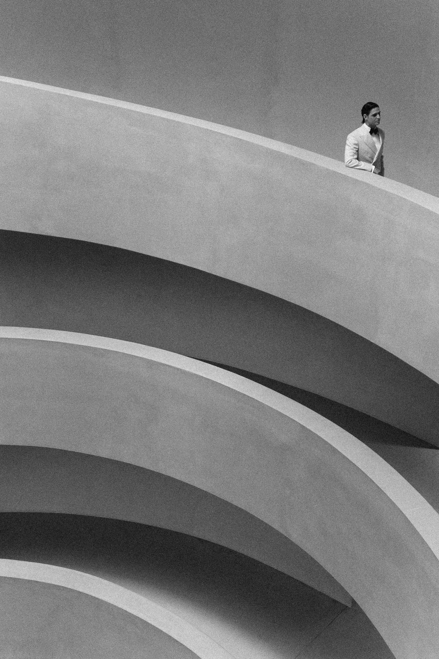 Black and white architectural photograph showing curved lines of a spiral ramp with minimalist geometric composition.