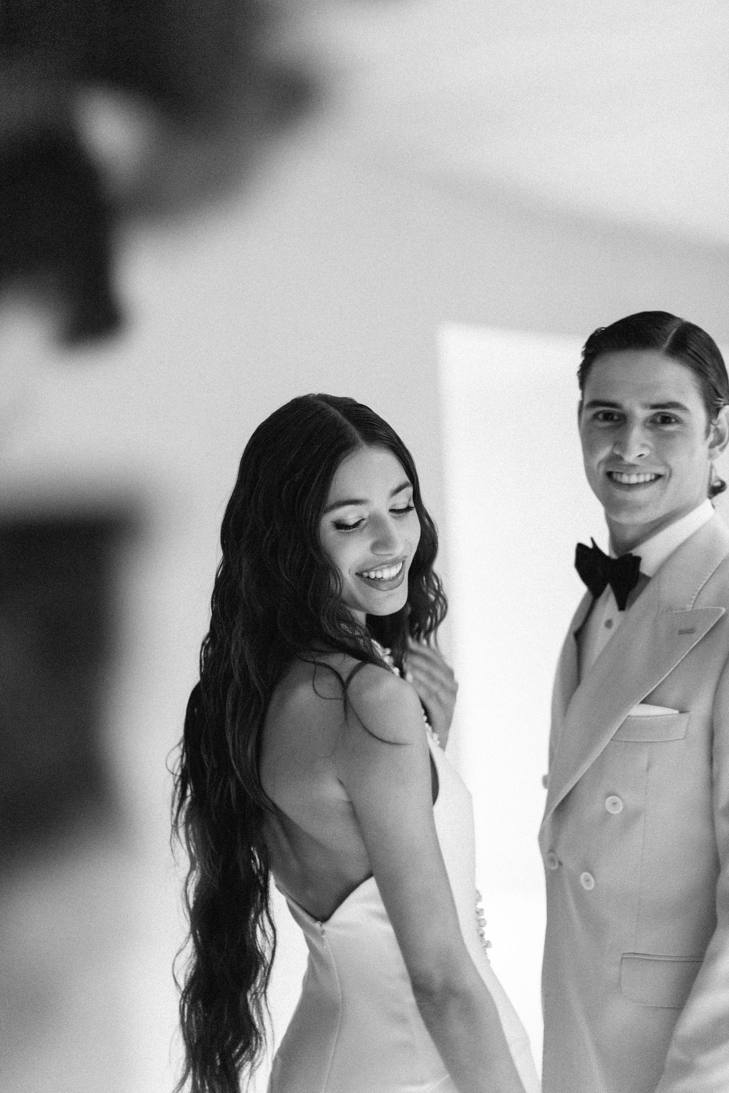 Artistic black and white wedding photoshoot with romantic poses against a white backdrop.