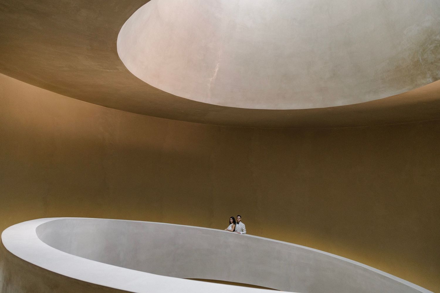 Modern architectural curves and lines in a minimalist concrete space.