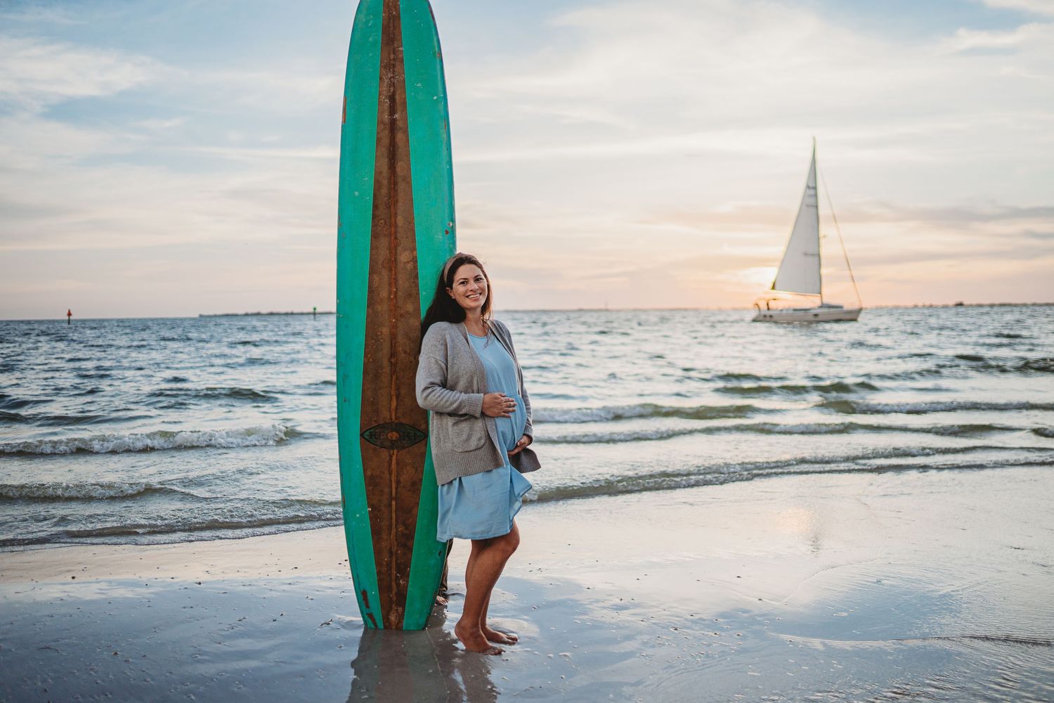 A series of beach sunset photos featuring a turquoise surfboard and a sailboat on the horizon.