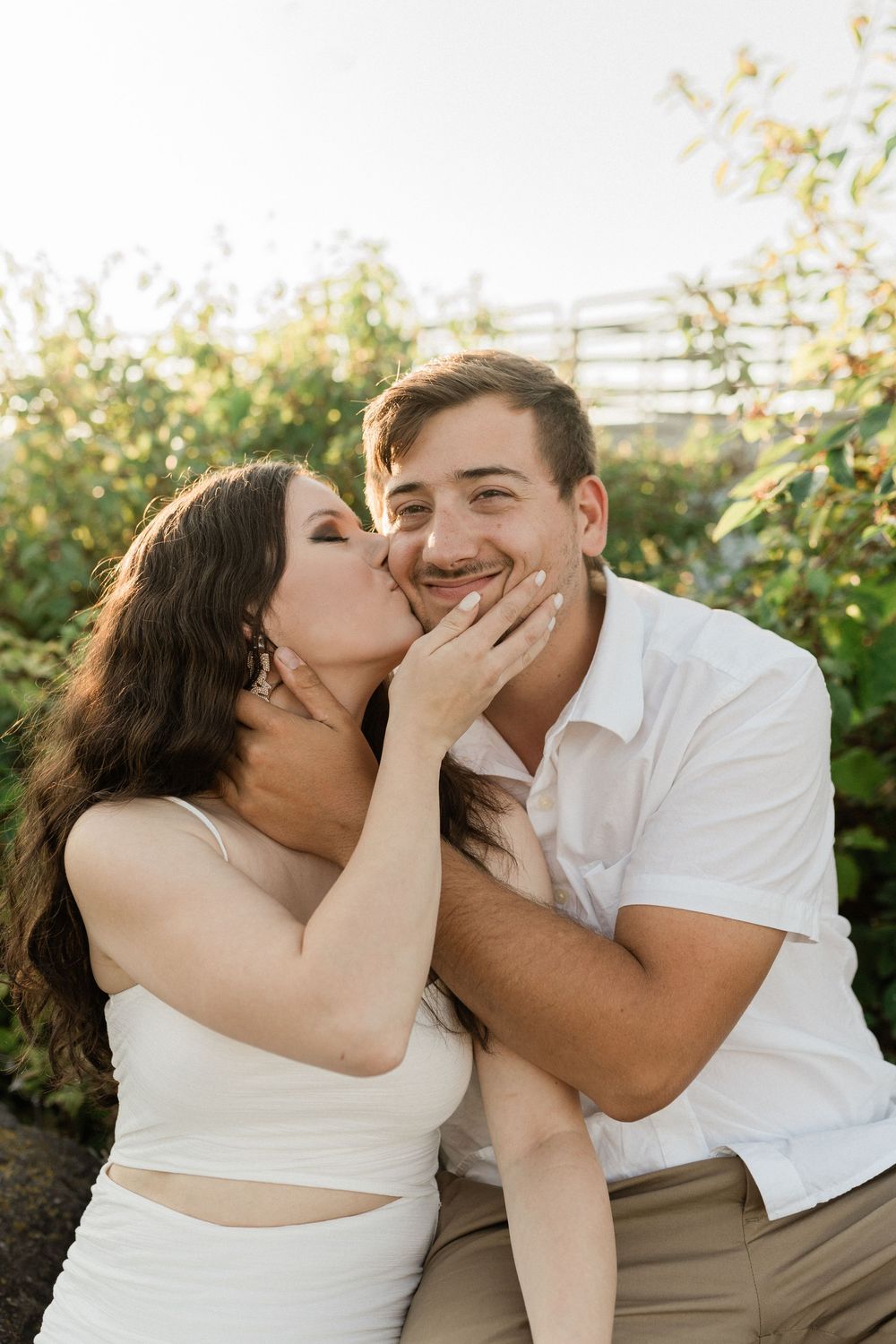 Romantic couple sharing an intimate moment in a garden during golden hour.
