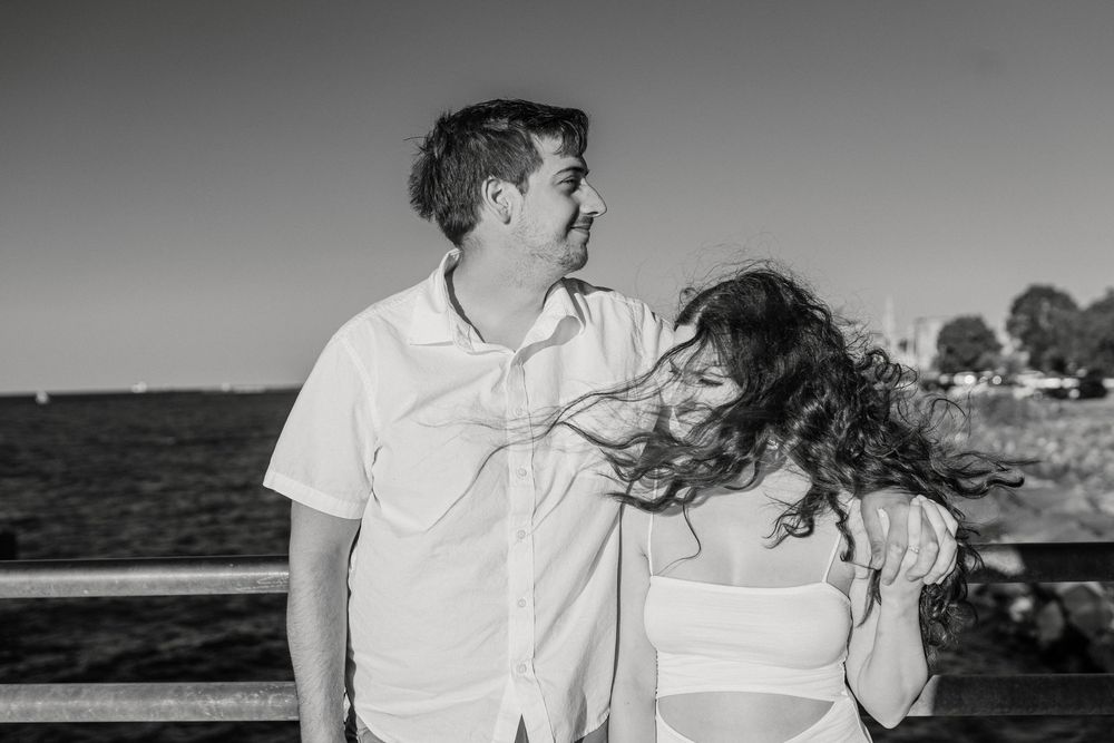 A couple embraces on a beach boardwalk during sunset with multiple romantic poses shown in sequence.