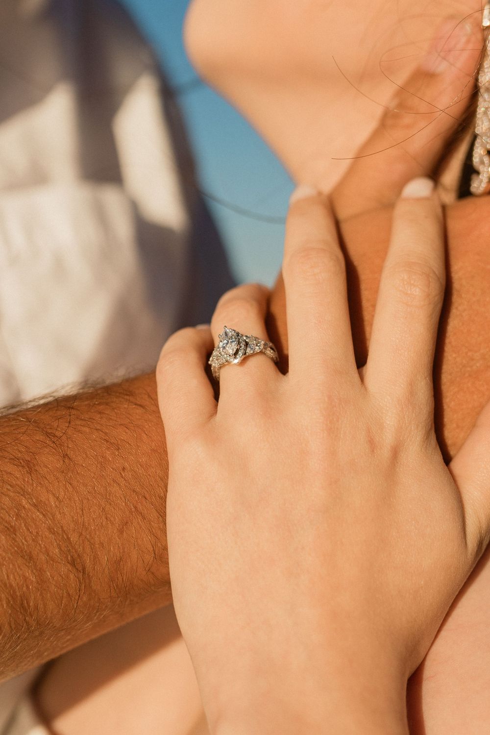 Close-up shot of hands with a sparkling engagement ring showing an intimate moment of love.