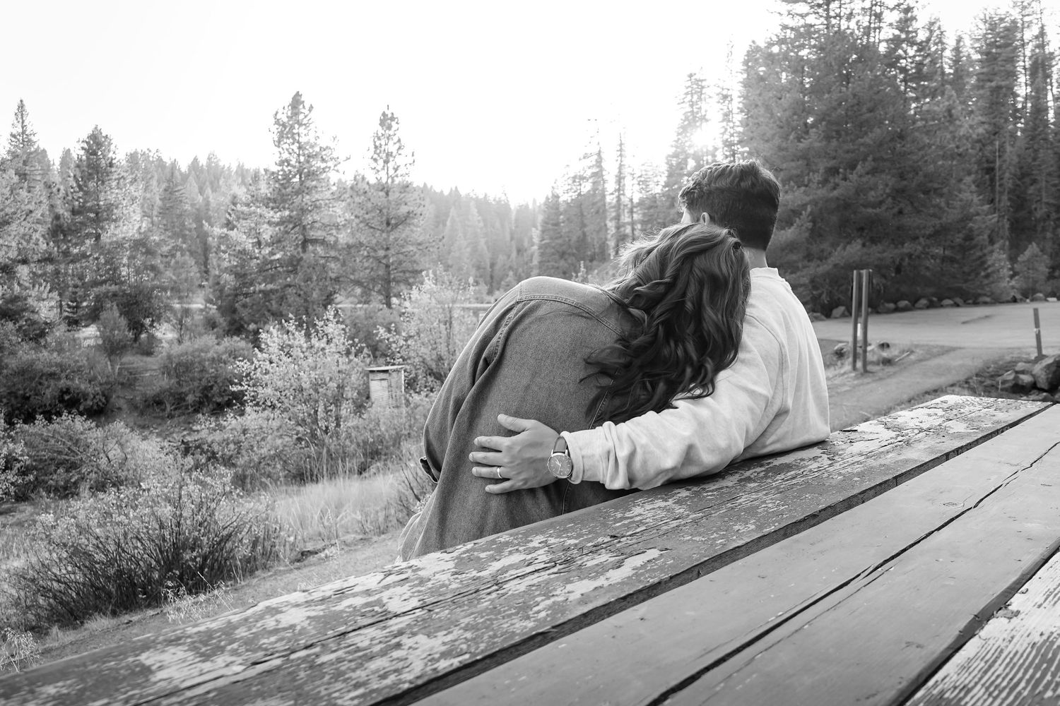 A tender scene unfolds along a backcountry road in a forested setting.
