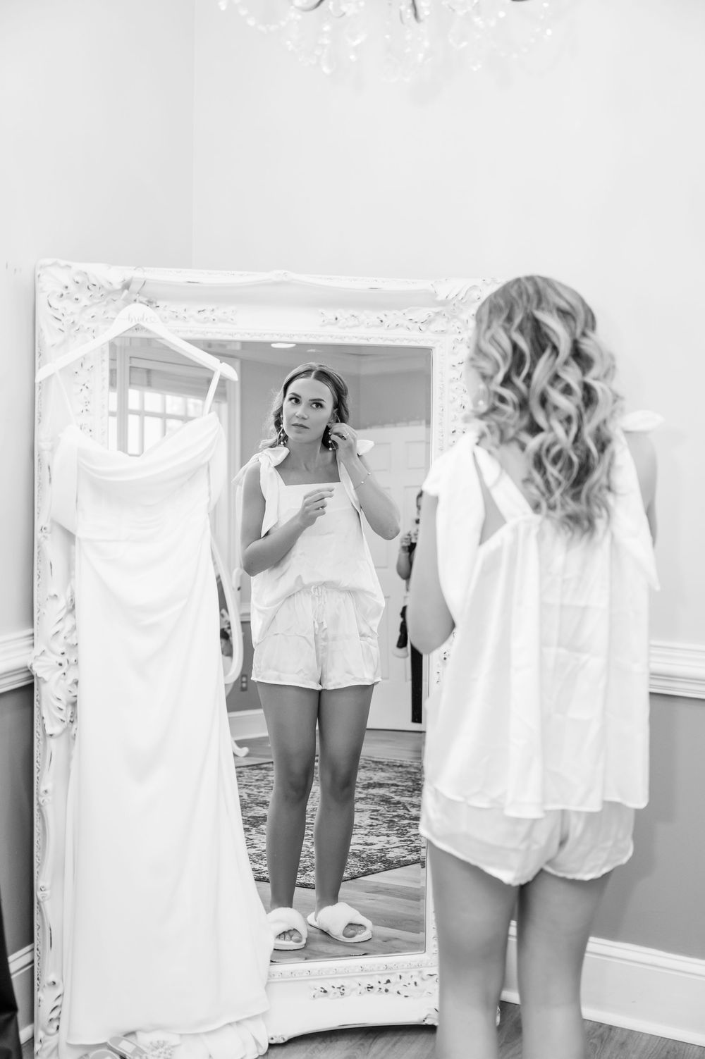 Black and white getting ready sequence showing wedding dress preparations in mirror reflections.