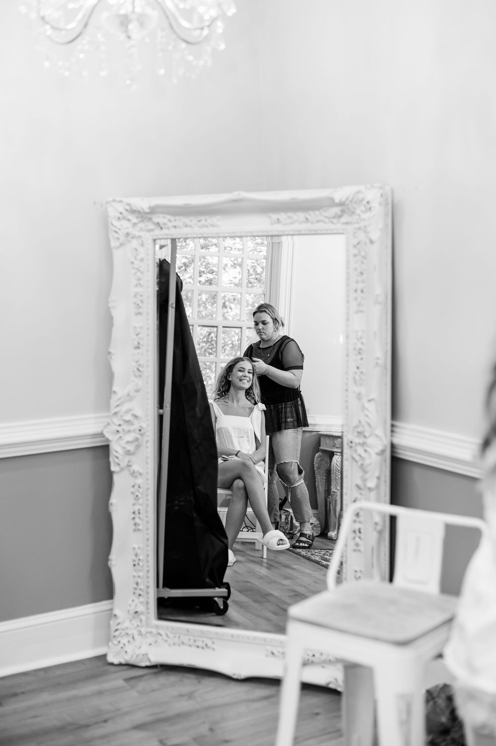 Black and white photos showing reflections in an ornate white mirror during wedding preparations.