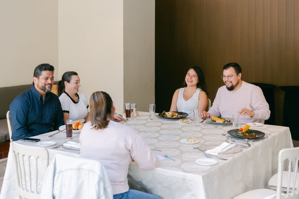 Panoramic view of a formal dining room with white tablecloths and guests enjoying a meal.