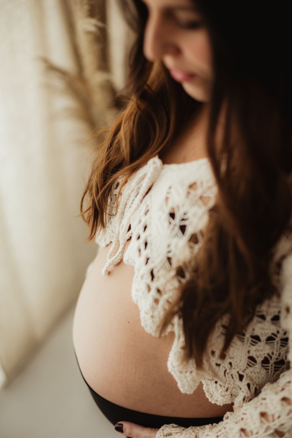 Close-up details of delicate white lace crochet pattern on a dress against a soft blurred background.