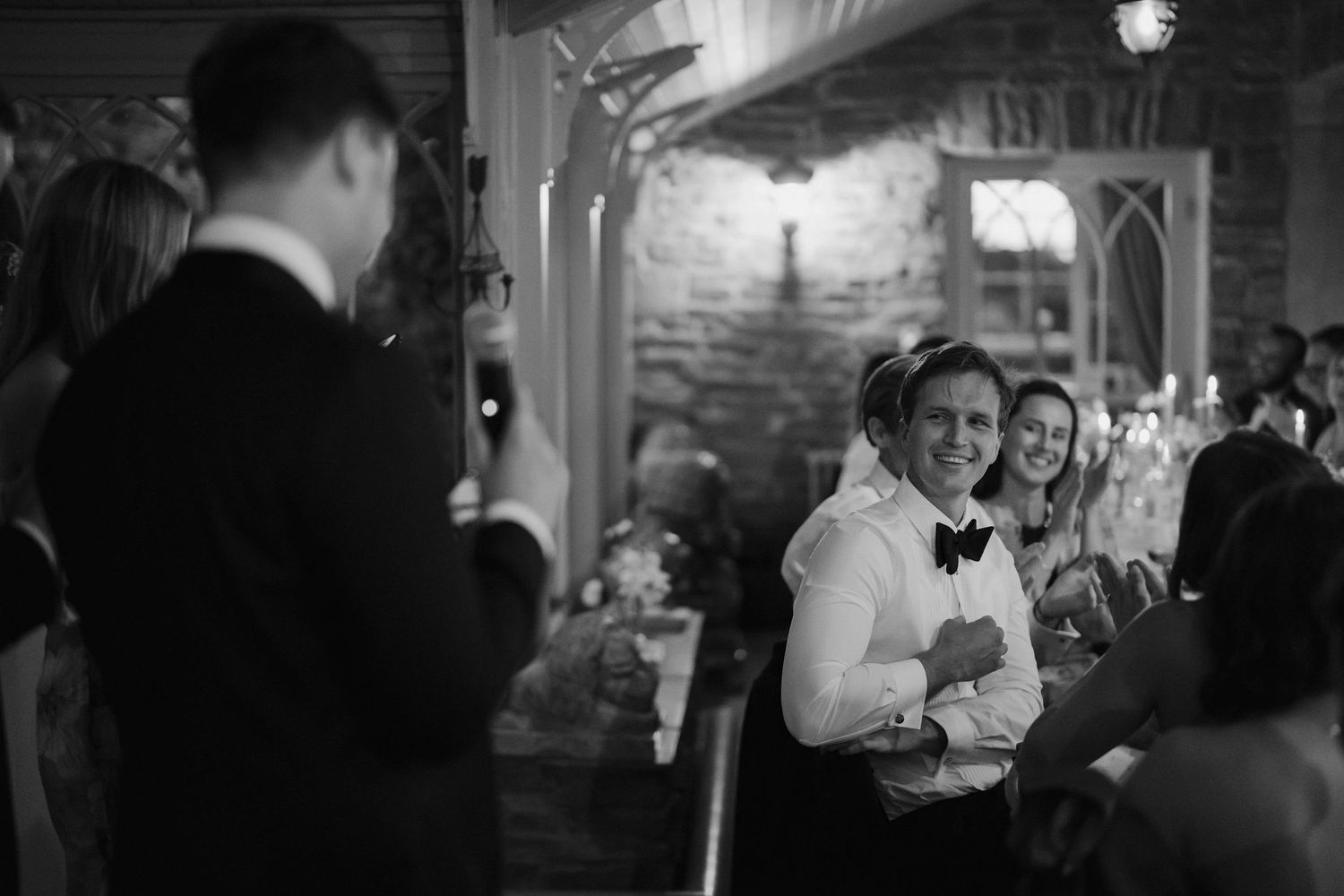 groom smiling at speaker during wedding speeches at dewsall court in herefordshire