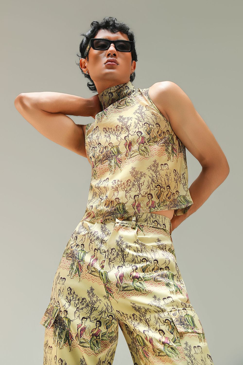 Person wearing matching gold brocade halter top and wide-leg pants with sunglasses, posing confidently against a neutral background.