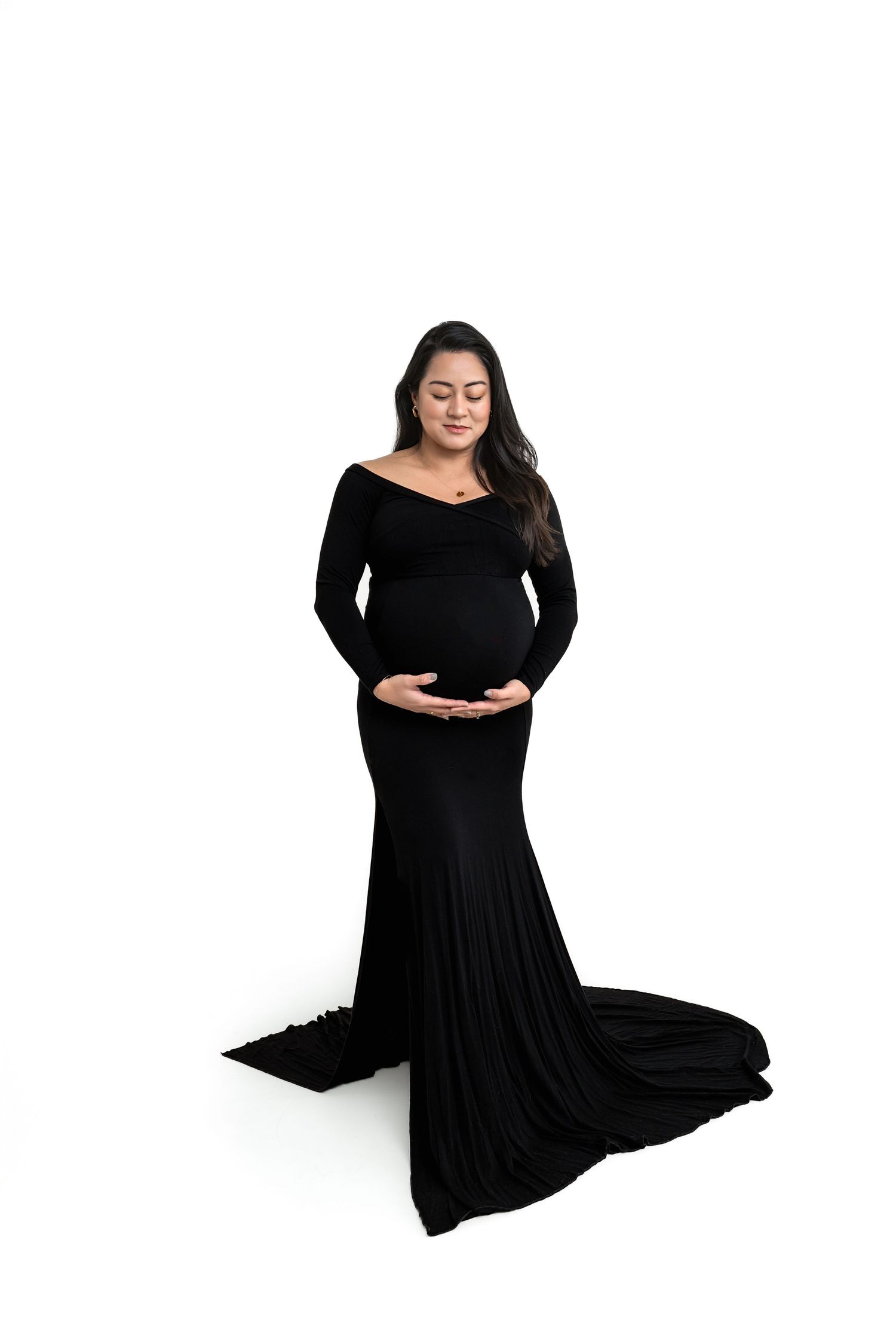 Classic maternity photo of a woman in a fitted black gown against a white background for studio maternity photos in Marietta.