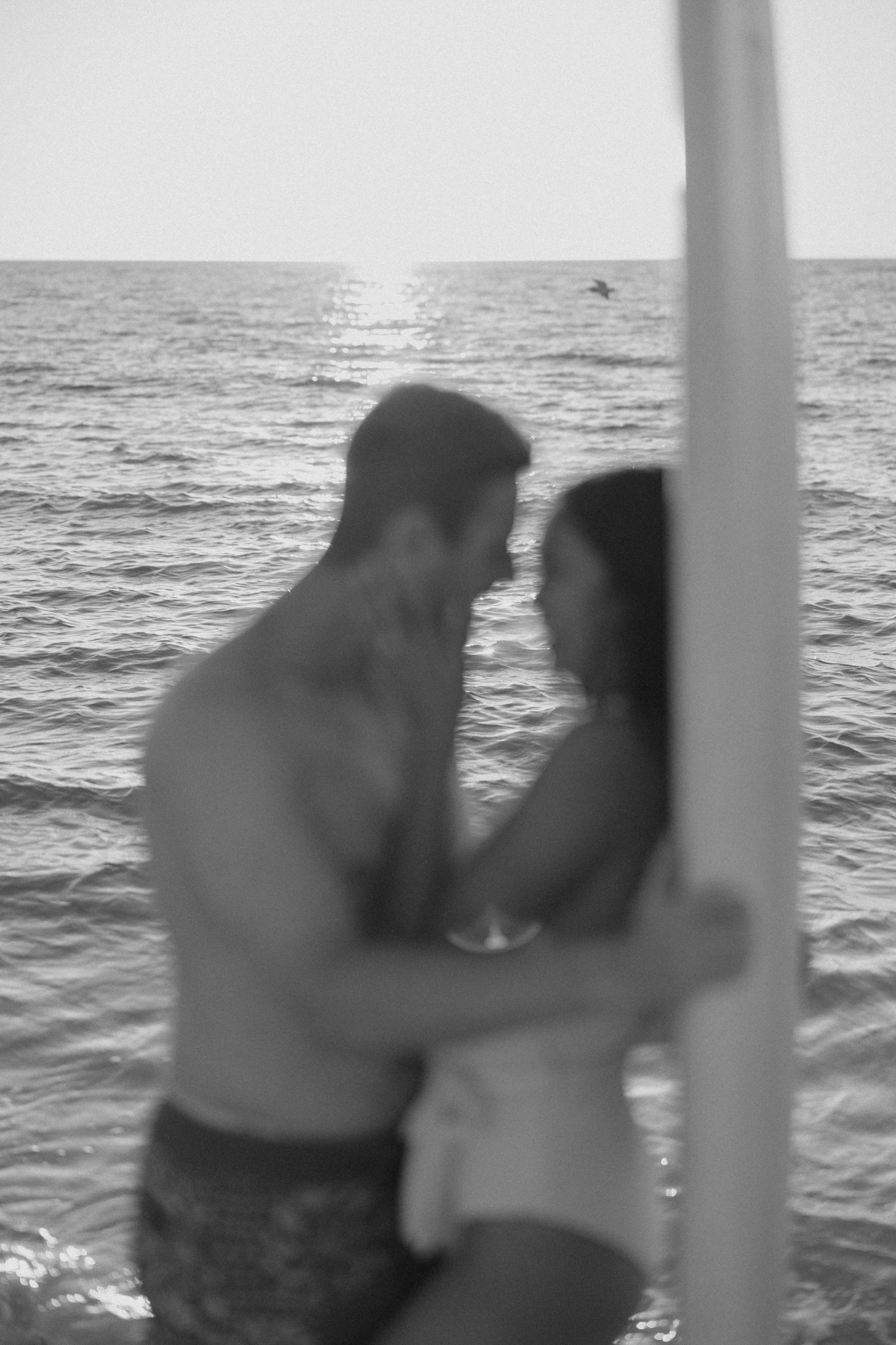 Romantic lifestyle couple portrait of a couple swimming in ocean together on the beach in soft natural light.