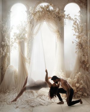 Two silhouetted figures in an ethereal white room with arched windows and floral decorations create a dreamy romantic scene.