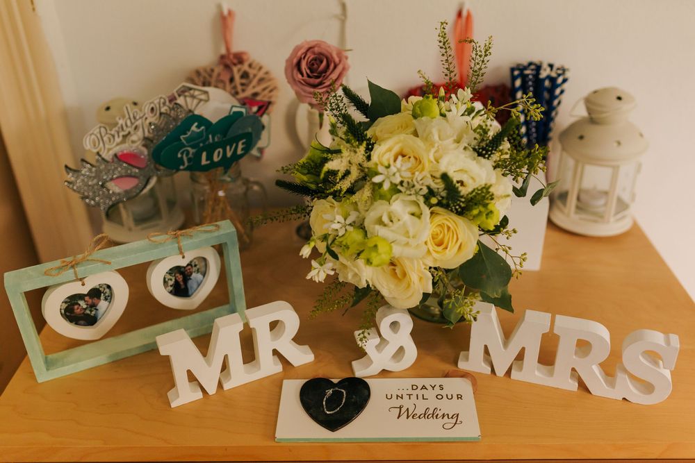 Wedding decoration table display with Mr and Mrs signs, floral bouquet, lantern and countdown card.